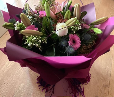 Blushing Harmony - A soft and elegant arrangement featuring delicate pink tones balanced with creamy accents and lush greenery. Wrapped in layered shades of pink, this hand-tied bouquet has a romantic, graceful feel—perfect for heartfelt occasions or simply adding a touch of beauty to any space.