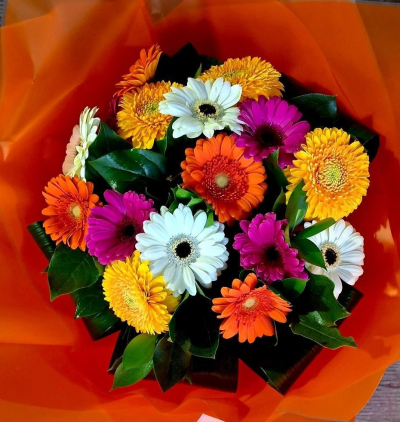 Gerbera Smiles - A bouquet of smiles and vibrancy.  Multi-coloured  gerberas and complimentary foliage