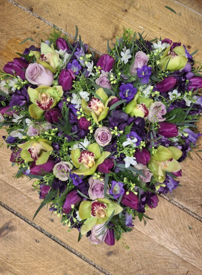 Purple and Lilac Heart - A beautiful heart tribute with lilac and purple seasonal flowers, Orchids when is season.
Flower content may vary due to seasonal availability.  Picture shown is 15".