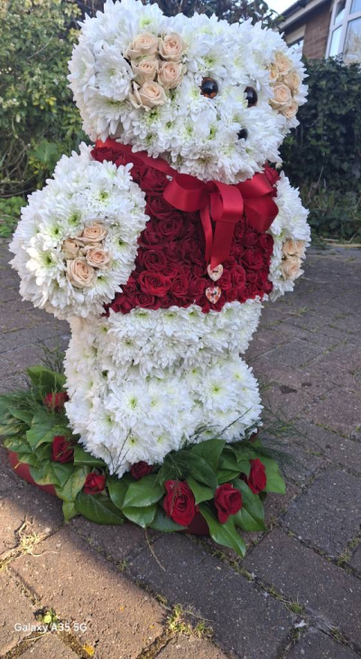 3D Standing Teddy - 3D Teddy mounted to a heart frame.  Body based with Chrysanthemums, Waistcoat, ears and paws are based with Spray Roses. Heart Base with Moss or Foliage and Roses.  The waistcoat can be pink, red, yellow, white, orange, Lilac. Please state in the special instructions box or phone the shop to discuss.