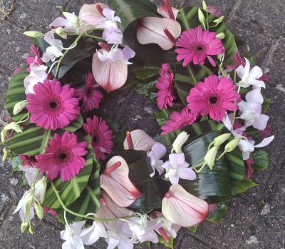 Grouped Pink and White Wreath - A contemporary wreath with Anthuriums, Gerbera and Dendrobium Orchid.  Tropical leaves